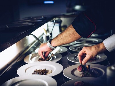 The hands of a chef, preparing some dishes